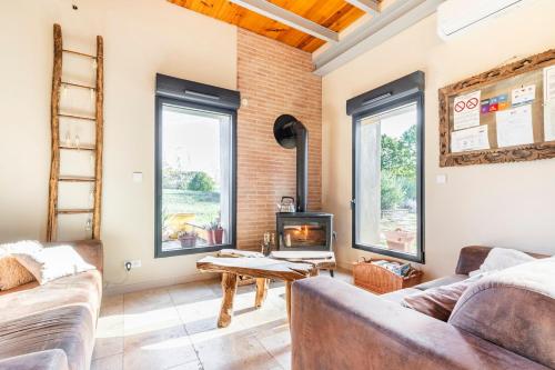 Una sala de estar con dos sofás y una chimenea. en Domaine des Jammetous - Hotel and Yoga Retreat Center, en La Magdelaine-sur-Tarn