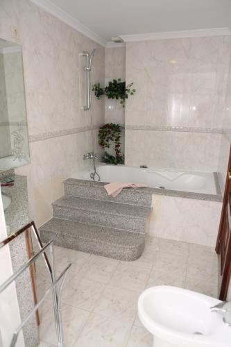 a bathroom with a bath tub and a sink at Hotel Santa Cruz in Montaos