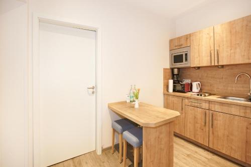 a small kitchen with a wooden table and a counter at Landhaus Nütschau in Bad Oldesloe