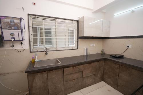 a kitchen with a sink and a window at GharBar in Indore