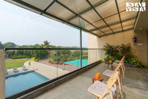 a view from the balcony of a house with a swimming pool at StayVista at Villa Lemonade with BBQ & Bonfire in Alibaug