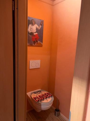 a bathroom with a toilet with a picture on the wall at Villa Stern bei FFM Viel Platz und eigener Zugang in Nidderau