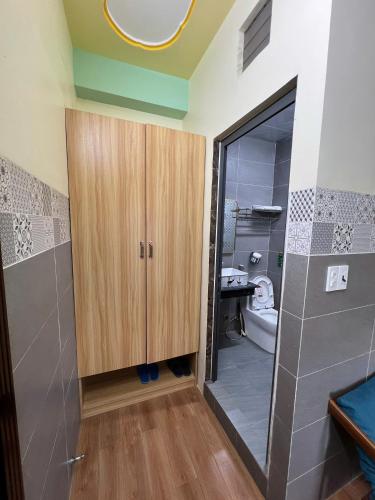 a bathroom with a wooden cabinet and a toilet at Như Ý Hotel in Kon Plong