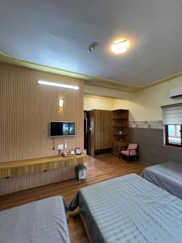 a hotel room with two beds and a flat screen tv at Như Ý Hotel in Kon Plong