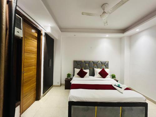 Un dormitorio con una cama grande con almohadas rojas. en Hotel Milton -Malviya Nagar, en Gurgaon