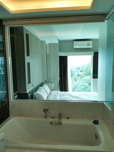 a bathroom with a large mirror over a bath tub at The new concept office plus in Ban Fon