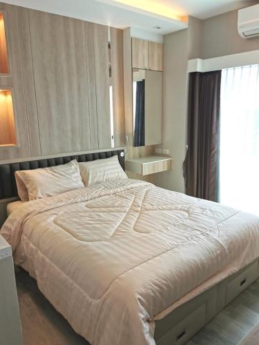 a bedroom with a large white bed with a window at The new concept office plus in Ban Fon