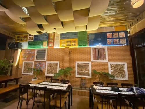 Un restaurante con mesas y sillas y una pared de ladrillos. en Chillin' House, en Cat Ba