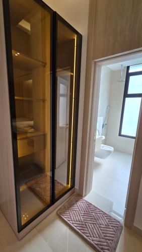 an empty glass cabinet in a room with a bathroom at Al Mona Resort 2 شاليه المنى in Al Khobar