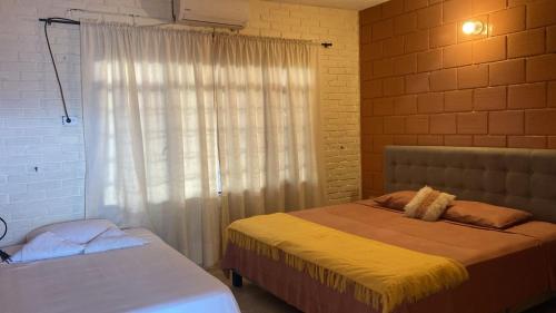 Un dormitorio con dos camas y una ventana. en Leño Verde, en Espinal