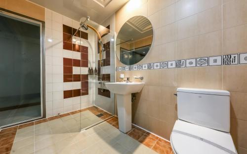 a bathroom with a sink and a toilet and a mirror at 천안 호텔 하루 in Tujŏng-dong