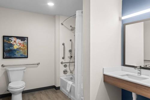 Everhome Suites Bowling Green في بولينغ غرين: حمام أبيض مع مرحاض ومغسلة