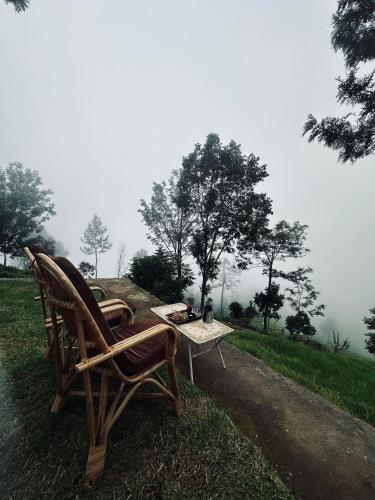 a couple of chairs and a table on a field at Moksha at Infinity Valley in Kotagiri