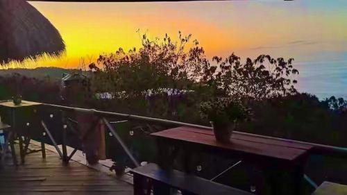 a sunset on a deck with a table and chairs at Villa Naila in San Agustinillo
