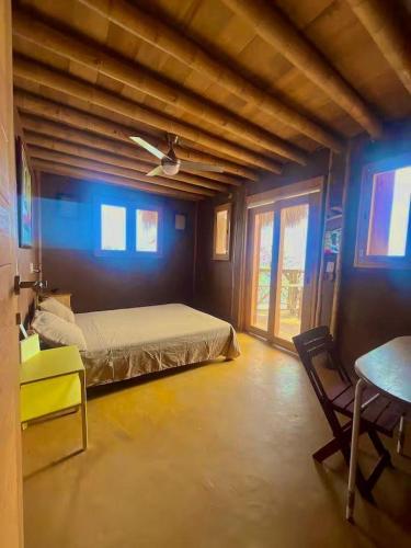 a bedroom with a bed and a table in a room at Villa Naila in San Agustinillo