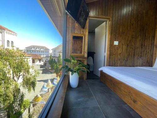 a bedroom with a bed and a window with a plant at Căn hộ Đà Lạt Cảnh in Da Lat