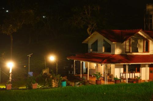 a house at night with lights in front of it at Moksha at Infinity Valley in Kotagiri