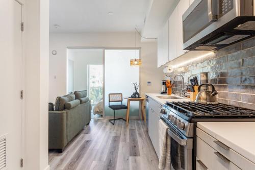 a kitchen with a stove top oven next to a couch at Boutique Mini 1 BD Residence in Los Angeles