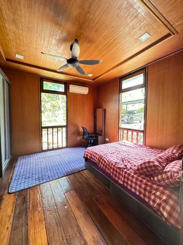 a bedroom with a bed and a ceiling fan at Indah Desa Homestay in Mantin