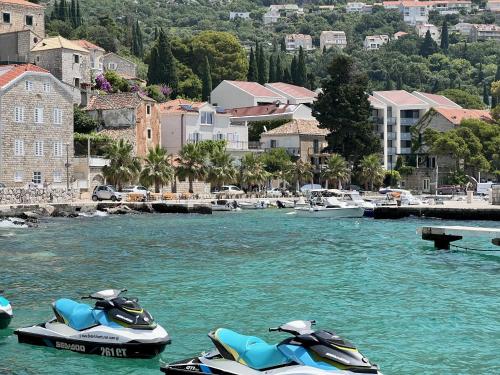 twee waterscooters geparkeerd in het water nabij een stad bij Apartment LaVilla in Mlini