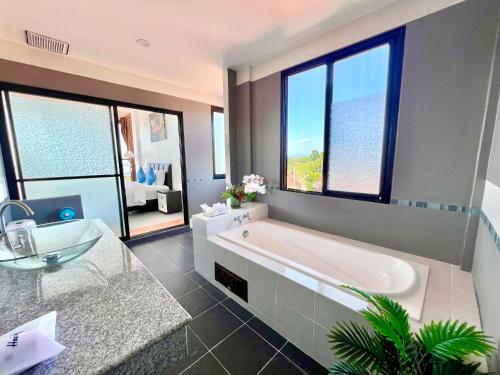 a large bathroom with a tub and a sink at Serenity by Peace Garden in Amphoe Koh Samui