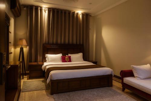 een hotelkamer met twee bedden en een bank bij Pinewood Guest House in Islamabad