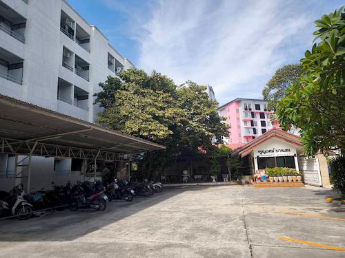 a parking lot with motorcycles parked next to a building at Jaroonwej Bangsaen in Bangsaen