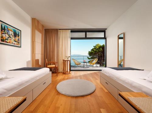 a bedroom with two beds and a view of the ocean at Villa Katina in Sućuraj