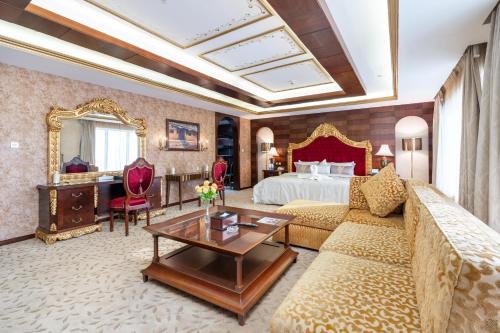 Una sala de estar con una cama, un sofá y una mesa. en Samaya Hotel Deira, en Dubái
