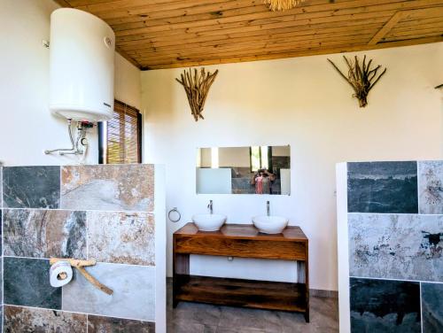 ein Badezimmer mit zwei Waschbecken und einem Spiegel in der Unterkunft Villa Natura in Ambondrona