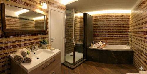 Motta di Livenza Deluxe - Deluxe Apartments Italia في موتا دي ليفينزا: حمام مع حوض استحمام ومغسلة ومرحاض