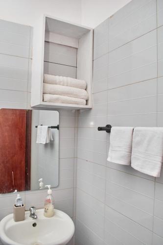 a bathroom with a sink and a mirror and towels at Swara house in Ukunda
