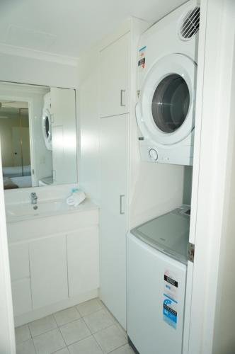 a washer and dryer in a white bathroom at Aussie Resort in Gold Coast