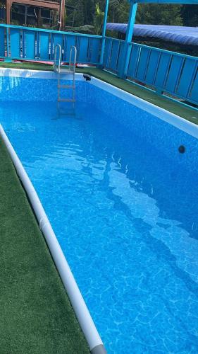 a large blue swimming pool with a ladder in it at Indah Desa Homestay in Mantin