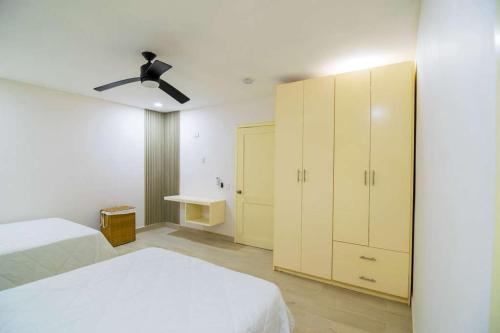 a bedroom with two beds and a ceiling fan at Summer Bay Luxury Suite - West End - Roatán in Coxen Hole