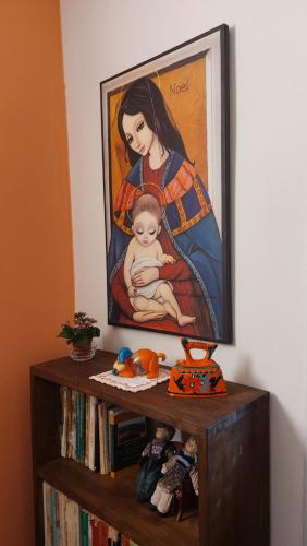 a painting of a woman holding a baby on a book shelf at Casa Zia Maria 6 posti Monterosso Coast to Coast in Monterosso
