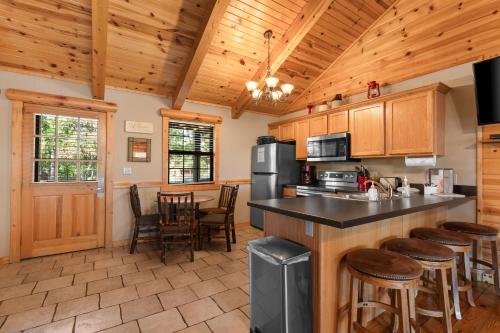 a kitchen with wooden cabinets and a counter with bar stools at Ozarks Oasis cabin in Branson