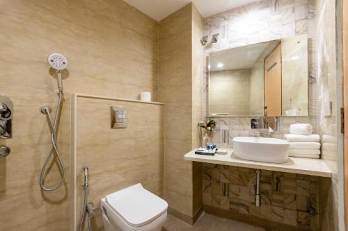 Un baño con lavabo, inodoro y espejo. en Hotel New King Castle International- Free Airport Pick up, en Nueva Delhi