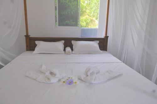 a bed with white towels on it with a window at Sunny's Hide Out in Talalla