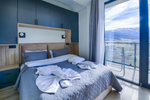 Babex Panorama في باكورياني: غرفة نوم مع مناشف على سرير مع نافذة
