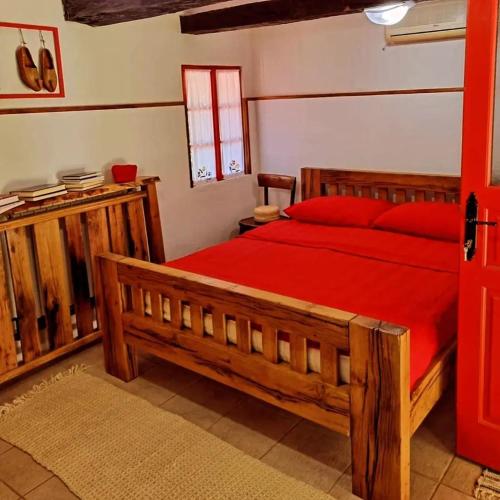 a bedroom with a large wooden bed with red pillows at Eko imanje Sunce, Rudnik in Gornji Milanovac