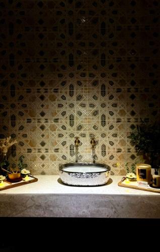 a bathroom with a sink and a tile wall at Iris Boutique Taif Heart in Taif