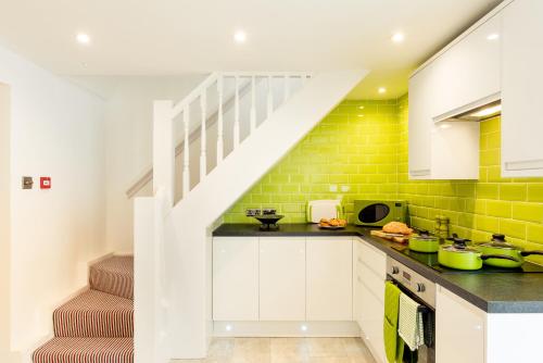 a kitchen with white cabinets and a staircase at The Beach House in Brighton & Hove