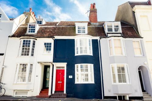a house with a red door on a street at The Beach House in Brighton & Hove