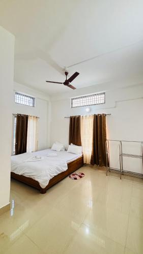 Un dormitorio con una cama y un ventilador de techo. en Toncheng Homestay, en Kāziranga