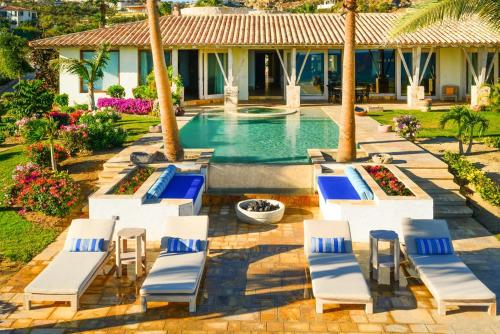 a group of lounge chairs and a swimming pool at Casa Piedra Blanca in San José del Cabo
