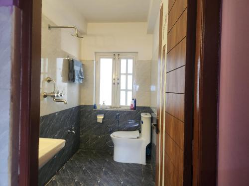 Un baño con inodoro, lavabo y bañera. en Below The Hills suite WHome Theatre, en Katmandú