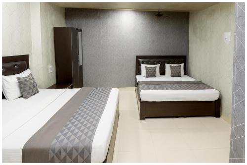 two beds in a hotel room with two beds at Dori Bazar Road Hotel Saurav Premium Palace Near Yamuna River - Shri Dwarkadhish Temple - Free Wi-Fi-Restaurant Car Parking facilities - Room Service ree Wifi # Free Wifi - Fully Air conditioning Room - Best Budget Hotel In Mathura in Mathura