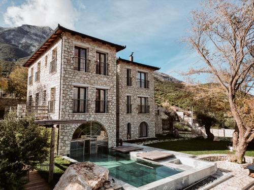 an old stone house with a swimming pool in front of it at Villa Si Era in Brataj