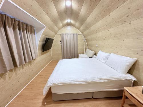 a bedroom with a large bed in a wooden room at Here after us homestay in Dahu